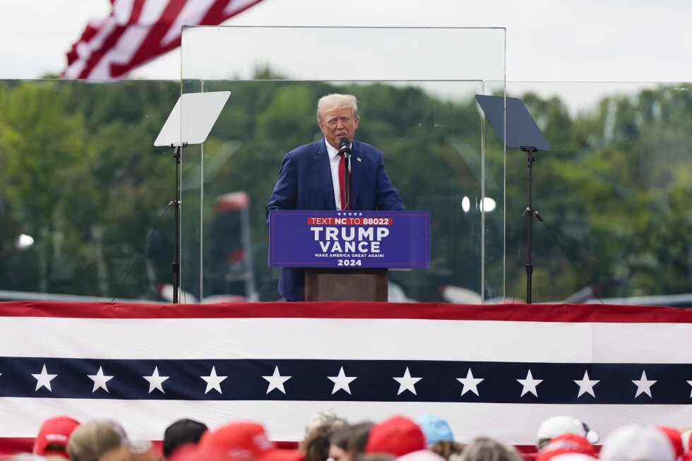 Trump aparece detrás de cristal antibalas en su primer evento al aire libre desde atentado